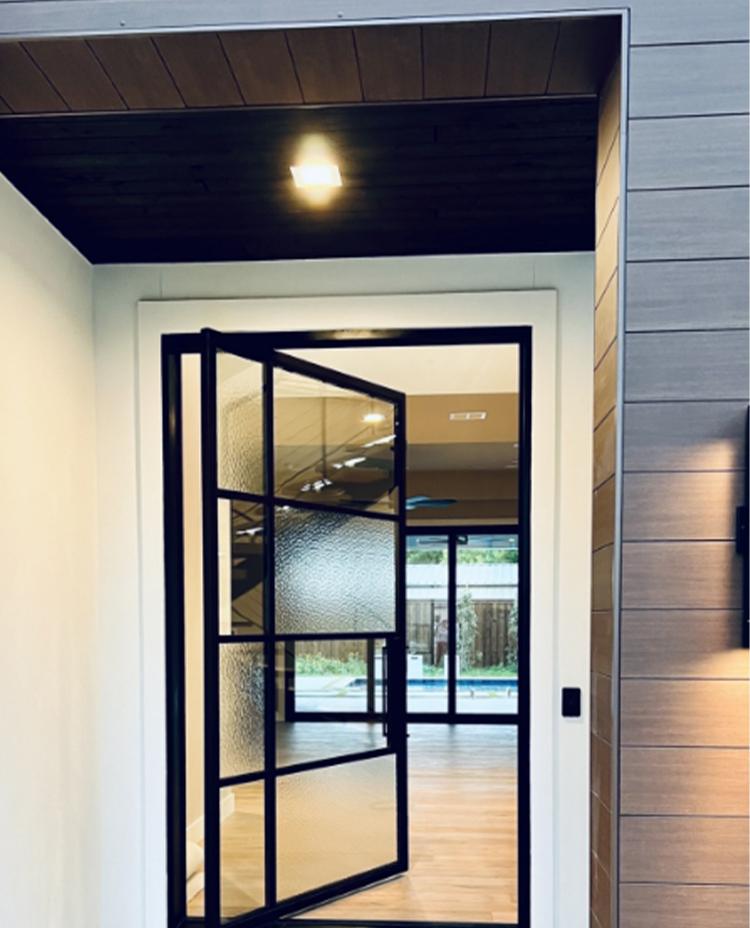 Large modern iron door opening into entry